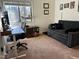 Bright office space featuring a modern desk, comfy sofa, and natural light from a large window at 203 Oak Tree Dr, Chapel Hill, NC 27517