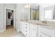 Bright bathroom featuring double sinks, white cabinets and a door leading to a walk-in closet at 238 Ashpole Trail Trl, Clayton, NC 27520