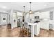 Spacious kitchen showcasing white cabinets, stainless steel appliances, and a center island with barstool seating at 238 Ashpole Trail Trl, Clayton, NC 27520