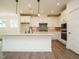 Kitchen boasts a central island, stainless appliances, white cabinets and hardwood floors at 267 Parkland Dr Dr, Pittsboro, NC 27312