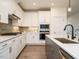 Kitchen boasts stainless appliances, white cabinets and hardwood floors, and modern hardware at 267 Parkland Dr Dr, Pittsboro, NC 27312