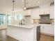 Kitchen features central island, stainless appliances, white cabinets and hardwood floors, and a view to the dining area at 267 Parkland Dr Dr, Pittsboro, NC 27312