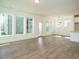 Open-concept living room with wood-look floors, leading to a kitchen with a center island at 267 Parkland Dr Dr, Pittsboro, NC 27312