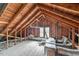 Unfinished attic with exposed wooden beams and ductwork, offering potential for customization at 301 Hillsborough St, Chapel Hill, NC 27514