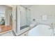 Bathroom with glass enclosed shower, tiled walls, and decorative mosaic flooring at 301 Hillsborough St, Chapel Hill, NC 27514