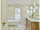 Elegant bathroom features a freestanding tub and a wooden vanity with double sinks at 301 Hillsborough St, Chapel Hill, NC 27514