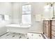 Bright bathroom with a clawfoot tub, white subway tile, and mosaic floor detailing at 301 Hillsborough St, Chapel Hill, NC 27514
