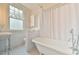 Bright bathroom features a clawfoot tub, stylish fixtures, and geometric tile floors at 301 Hillsborough St, Chapel Hill, NC 27514