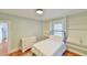 Comfortable bedroom with a twin bed, hardwood floors, built-in shelving, and natural light at 301 Hillsborough St, Chapel Hill, NC 27514