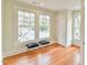 Light-filled bedroom with hardwood floors and two large windows overlooking the street at 301 Hillsborough St, Chapel Hill, NC 27514