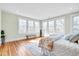 Bright bedroom featuring large windows, hardwood floors, and a stylish patterned bed at 301 Hillsborough St, Chapel Hill, NC 27514