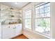 Butler's pantry featuring white cabinets, open shelving, and natural light from large windows at 301 Hillsborough St, Chapel Hill, NC 27514