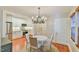 Open dining room featuring hardwood floors, an elegant chandelier, and an adjacent modern kitchen at 301 Hillsborough St, Chapel Hill, NC 27514
