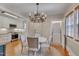 Bright dining room with hardwood floors, an elegant chandelier, and modern appliances in view at 301 Hillsborough St, Chapel Hill, NC 27514