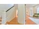 Bright hallway features hardwood floors, white staircase, and an open doorway to the living room at 301 Hillsborough St, Chapel Hill, NC 27514