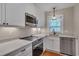 Bright kitchen with stainless steel appliances, white cabinets, and light granite countertops at 301 Hillsborough St, Chapel Hill, NC 27514