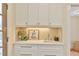 Charming butler's pantry features a sink with a decorative backsplash and white cabinets at 301 Hillsborough St, Chapel Hill, NC 27514