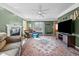 Spacious living room boasts a ceiling fan, fireplace, large window and a patterned area rug at 304 Briarwood Dr, Mebane, NC 27302