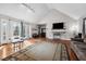 Open-plan living room with vaulted ceiling, hardwood floors, large windows, and access to outdoor patio at 304 Briarwood Dr, Mebane, NC 27302