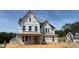 Two-story house under construction featuring a gable roof, multiple windows, and a framed porch, set against a blue sky at 3200 Balcon Ct # 28, Angier, NC 27501