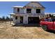 New two-story construction featuring a two-car garage, visible framing, and Tyvek house wrap at 33 W Emily Gardens Dr, Selma, NC 27576