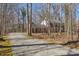 Long paved driveway leading to a two-story brick home surrounded by trees at 350 W Lake Trl, Mebane, NC 27302