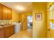 Well-lit laundry room with washer, dryer, storage cabinets, and doorway to the living area at 350 W Lake Trl, Mebane, NC 27302