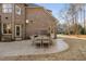 Spacious back patio with outdoor dining set for entertaining, adjacent to a lush lawn and brick home at 3905 Grandbridge Dr, Apex, NC 27539