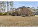 Large backyard featuring a brick home, screened in porch, and outdoor dining area at 3905 Grandbridge Dr, Apex, NC 27539