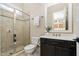 Bathroom features glass shower, black vanity, and large mirror at 3905 Grandbridge Dr, Apex, NC 27539