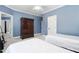 Bedroom with two twin beds, light blue walls, white trim, and a dark wood armoire at 3905 Grandbridge Dr, Apex, NC 27539