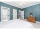 Comfortable bedroom with neutral carpet, white trim, and doors, featuring a charming wood dresser at 3905 Grandbridge Dr, Apex, NC 27539