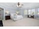 This main bedroom offers a ceiling fan, accent windows and cozy carpet for relaxation at 3905 Grandbridge Dr, Apex, NC 27539