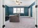 This bonus room offers a cozy spot to relax, with its neutral carpet and blue accent wall with modern windows at 3905 Grandbridge Dr, Apex, NC 27539