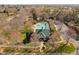 Aerial view of a community pool with a green roof pool house, white fence and mature trees at 3905 Grandbridge Dr, Apex, NC 27539