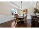 Elegant dining room boasts wainscoting, dark wood floors, a large window, and stylish decor for memorable gatherings at 3905 Grandbridge Dr, Apex, NC 27539