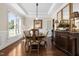 Formal dining room with coffered ceilings, dark wood floors, a large window, and elegant decor for memorable gatherings at 3905 Grandbridge Dr, Apex, NC 27539