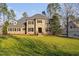 Charming two-story stone and brick home with an expansive lawn, mature trees, and classic black shutters at 3905 Grandbridge Dr, Apex, NC 27539
