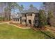 Elegant stone and brick home with a manicured lawn, professional landscaping, and classic shutters at 3905 Grandbridge Dr, Apex, NC 27539