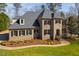 Elegant stone and brick home with a manicured lawn, professional landscaping, and classic shutters at 3905 Grandbridge Dr, Apex, NC 27539