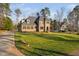 Sprawling brick and stone home with a lush front lawn, a long driveway, and mature trees at 3905 Grandbridge Dr, Apex, NC 27539