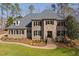 Elegant stone and brick home with a manicured lawn, professional landscaping, and classic shutters at 3905 Grandbridge Dr, Apex, NC 27539