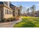 Brick and stone home featuring manicured landscaping, a curved walkway, and traditional black shutters at 3905 Grandbridge Dr, Apex, NC 27539
