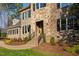 Elegant stone and brick home featuring a covered front entry, professional landscaping, and classic shutters at 3905 Grandbridge Dr, Apex, NC 27539
