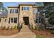 Elegant stone and brick home featuring a covered front entry, professional landscaping, and classic shutters at 3905 Grandbridge Dr, Apex, NC 27539
