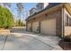 Attached three-car garage with neutral doors, brick siding, and decorative potted plants at 3905 Grandbridge Dr, Apex, NC 27539