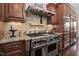 Gourmet kitchen boasts a stainless steel range with hood, custom cabinetry, and granite countertops, perfect for culinary enthusiasts at 3905 Grandbridge Dr, Apex, NC 27539