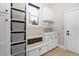Laundry room features white cabinets, sink, bench, and storage baskets at 3905 Grandbridge Dr, Apex, NC 27539