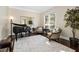 Bright living room with piano, large window, neutral colors, and hardwood flooring at 3905 Grandbridge Dr, Apex, NC 27539