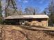 Charming one-story brick home featuring a metal roof, traditional shutters, and a small front porch at 4032 Chaucer Dr, Durham, NC 27705